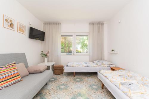 a living room with two beds and a couch at Malinowka in Jantar