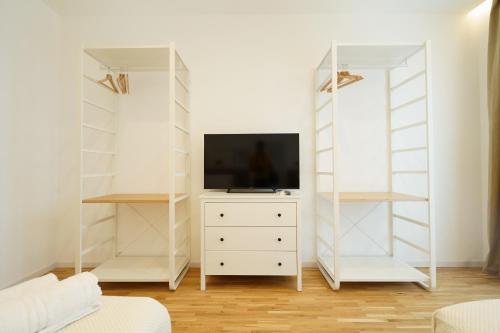 a living room with white shelves and a tv on a dresser at La Marina Case Vacanze in Augusta