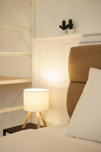 a lamp next to a bed and a chair at La Marina Case Vacanze in Augusta