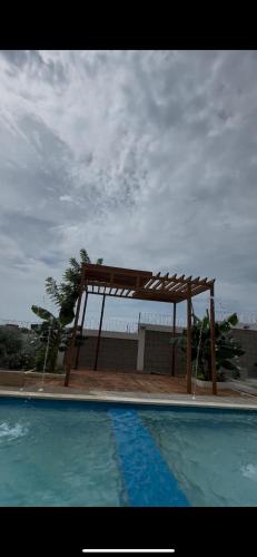 a wooden structure next to a swimming pool at Cabaña Eterno Nirvana in Santa Veronica