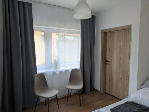 1 dormitorio con 2 sillas y ventana en Villa Hrachovo, 