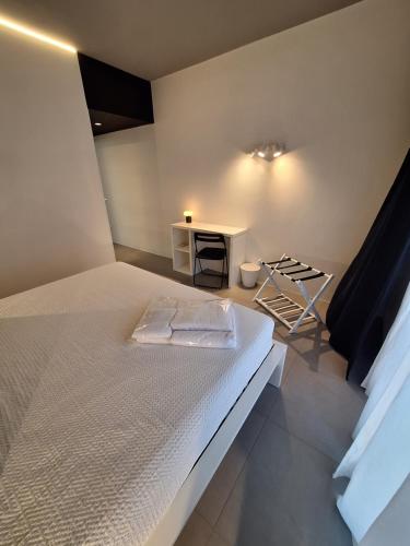 a bedroom with a white bed and a table at Perla delle Egadi in Marsala