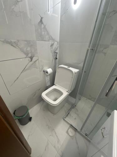 a white bathroom with a toilet and a shower at Bloem in Komotini
