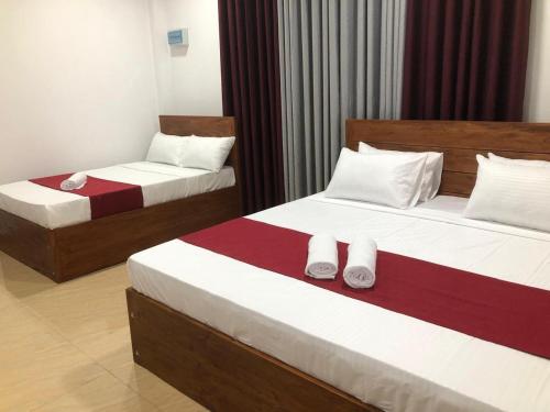 two beds in a hotel room with towels on them at Kandy Home Stay in Kandy