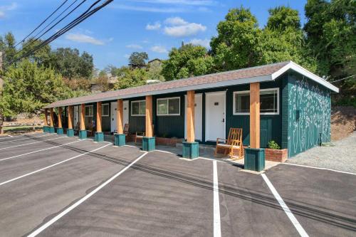 a green building in a parking lot at The Moro | Sequoia Motel RM3 in Three Rivers