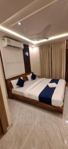 a bedroom with a large bed with blue pillows at Hotel Buransh inn Ghugtani secret Waterfall Road Tapovan Rishikesh in Rishīkesh