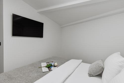 a white room with a bed and a tv at Berge Apartments in Kotor
