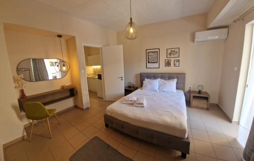 a bedroom with a bed and a chair and a mirror at Urban City Apartments in Xylokastro