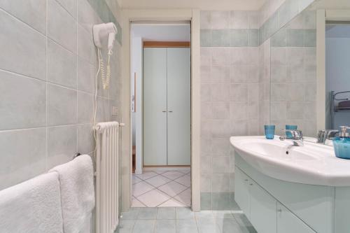 a white bathroom with a sink and a mirror at Green Village Accommodations in Colico