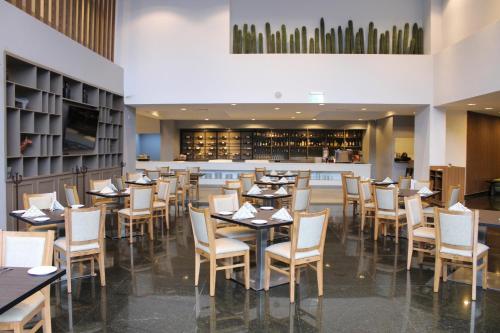 a dining room with tables and chairs and a bar at Holiday Inn Mexico Dali Airport by IHG in Mexico City