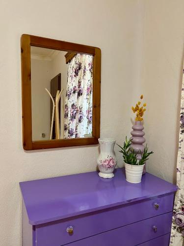 a purple dresser with a mirror and a purple drawer at Yiayias House in Limenaria