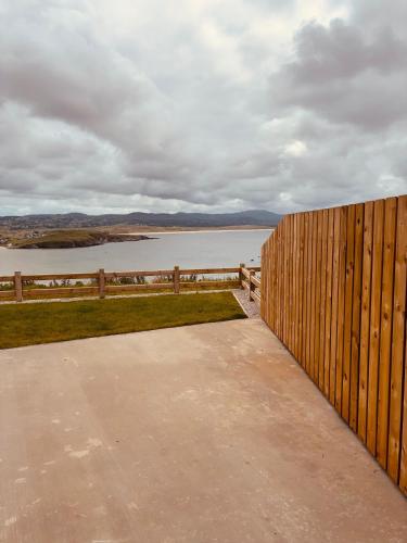 a wooden fence with a view of a body of water at Teach Máire, Downings in Downings