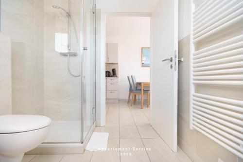 Un baño blanco con ducha y WC. en Ferienwohnung Fördekönig, en Laboe