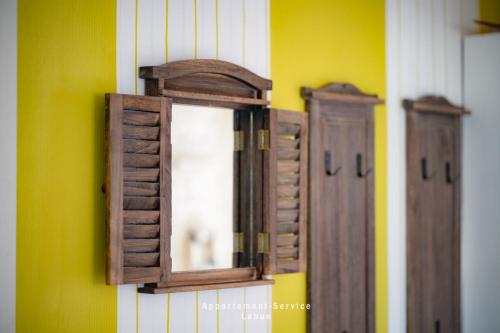 two wooden doors and mirrors on a wall at Fewo Kuhnert in Laboe