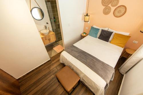 a small bedroom with a bed and a shower at La Martina Boutique Hotel in Medellín