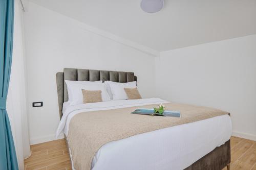 a bedroom with a large bed with a book on it at Berge Apartments in Kotor