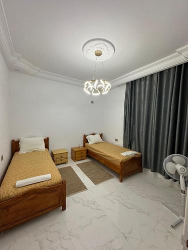 a bedroom with two beds and a window at Villa Line Midoun sans vis-à-vis in Taguermess