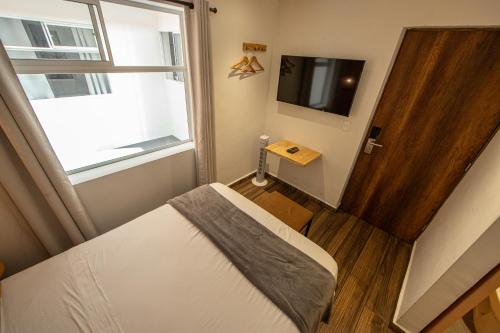 a small bedroom with a bed and a window at La Martina Boutique Hotel in Medellín