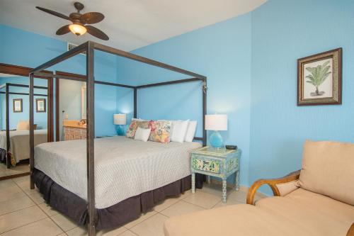a bedroom with a canopy bed and a couch at Happy-N-The-Sun 2 BR Oceanfront in Puerto Peñasco