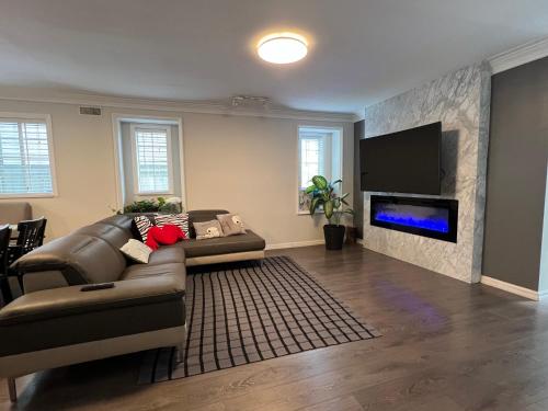 a living room with a couch and a flat screen tv at Vancouver Airport 7 mins away Cozy room Richmond near YVR in Richmond