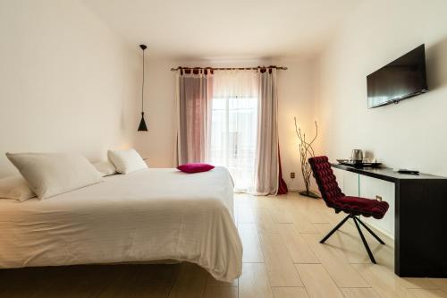 a bedroom with a bed and a desk and a chair at Kinbe Hotel Boutique in Playa del Carmen