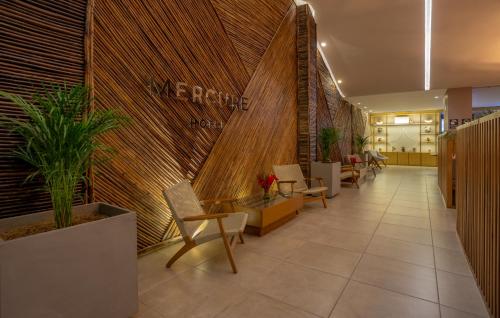 a lobby with chairs and tables in a building at Mercure Santa Marta Emile in Santa Marta