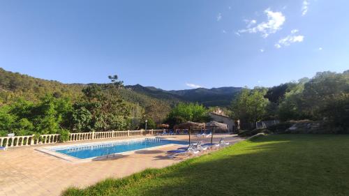 a swimming pool in a yard with mountains in the background at Finca La Celada in Moratalla