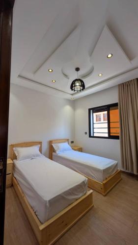 Un dormitorio con dos camas y una ventana. en Wino Surf House, en Imsouane