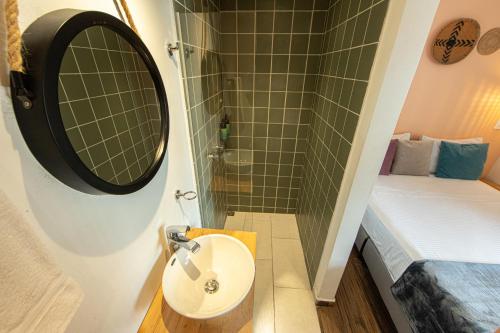 a bathroom with a sink and a shower and a mirror at La Martina Boutique Hotel in Medellín
