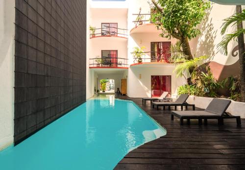 a swimming pool in front of a building at Kinbe Hotel Boutique in Playa del Carmen