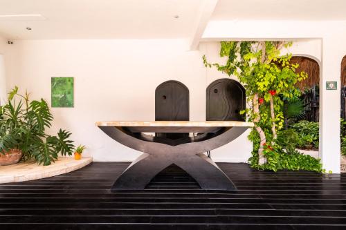 a table in the middle of a room with plants at Kinbe Hotel Boutique in Playa del Carmen