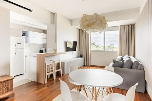 a white living room with a white table and chairs at Flat Belverede in Belo Horizonte