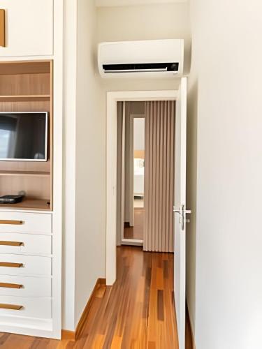 a hallway with a door leading to a kitchen with a ceiling at Flat Belverede in Belo Horizonte