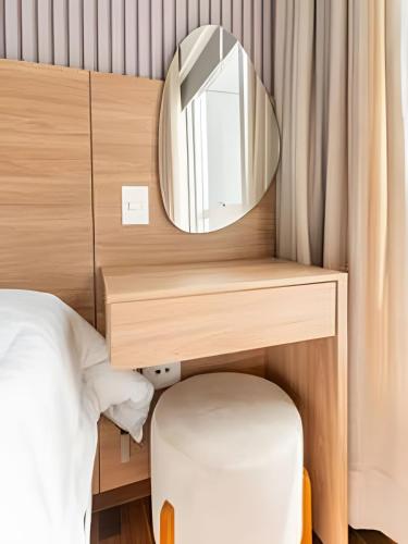 a dressing table with a mirror and a bed at Flat Belverede in Belo Horizonte
