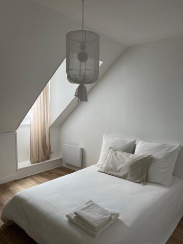 a bedroom with a white bed with a window at Le Petit Cottage - Appartement Centre-Ville & Plage in Concarneau