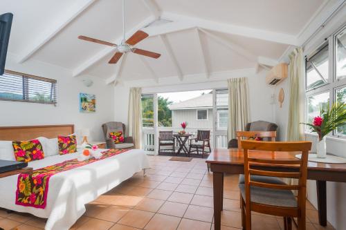a bedroom with a bed and a table and chairs at The Cooks Oasis in Rarotonga