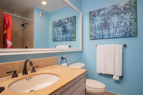 a bathroom with a sink and a toilet and a mirror at Happy-N-The-Sun 2 BR Oceanfront in Puerto Peñasco