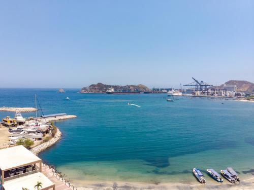 a view of a beach with boats in the water at Mercure Santa Marta Emile in Santa Marta