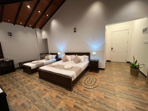 a large bedroom with two beds and a door at Villa Sole in Kandy