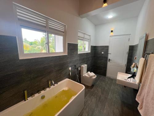 a bathroom with a large tub and a window at Villa Sole in Kandy