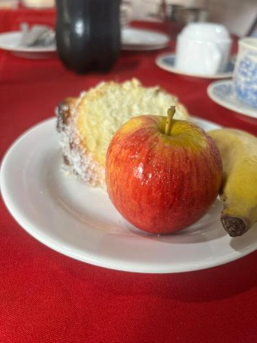 an apple and a piece of fruit on a plate on a table at Hotel e Restaurante Casa Velha in Barra Longa