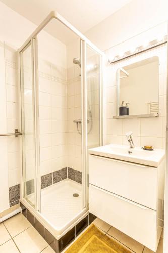 a white bathroom with a shower and a sink at Apartment Douillet in Saint-James