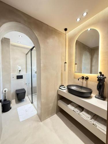 ein Badezimmer mit schwarzem Waschbecken und Toilette in der Unterkunft Noam Luxury Hotel in Sarandë