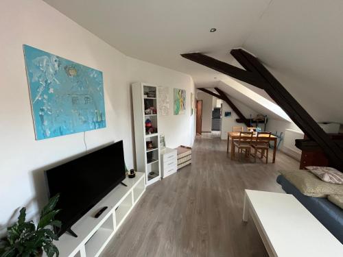 a living room with a television and a dining room at Ubytování v podkroví - Hlinsko. in Hlinsko