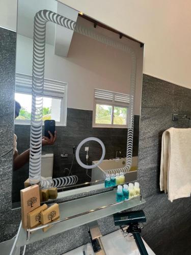 a person taking a picture of a bathroom mirror at Villa Sole in Kandy