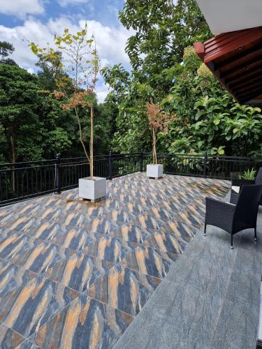 a patio with two chairs and two trees on it at Villa Sole in Kandy
