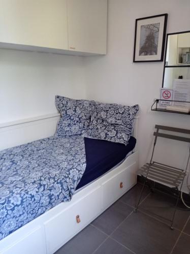 - une chambre avec un lit doté d'une couette bleue et d'une chaise dans l'établissement Studio proche de Paris, à Saint-Cloud