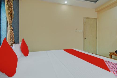 a bedroom with a red and white bed and a door at Hotel O Sai City inn in Jādabpur
