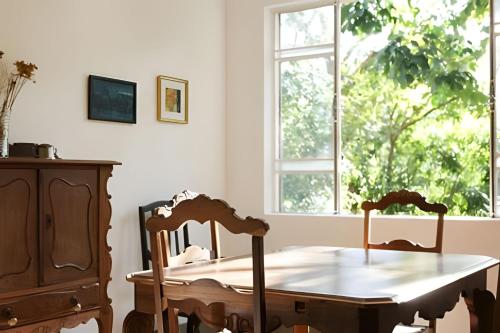 a dining room table with two chairs and a window at Natureza e Sossego em BH in Macacos