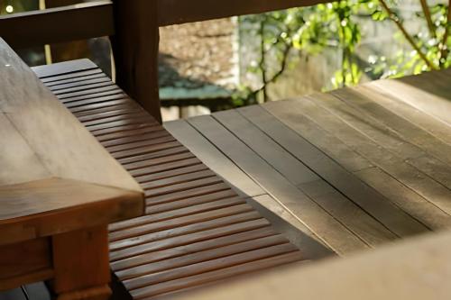 a wooden bench sitting next to a table at Natureza e Sossego em BH in Macacos